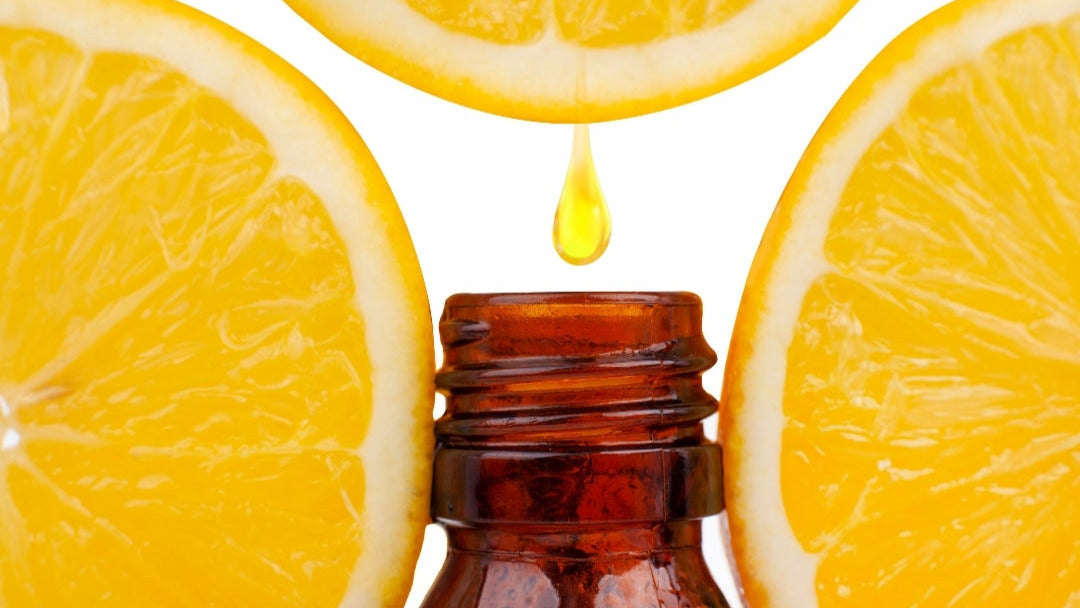 Bottle with a droplet surrounded by orange slices on a white background
