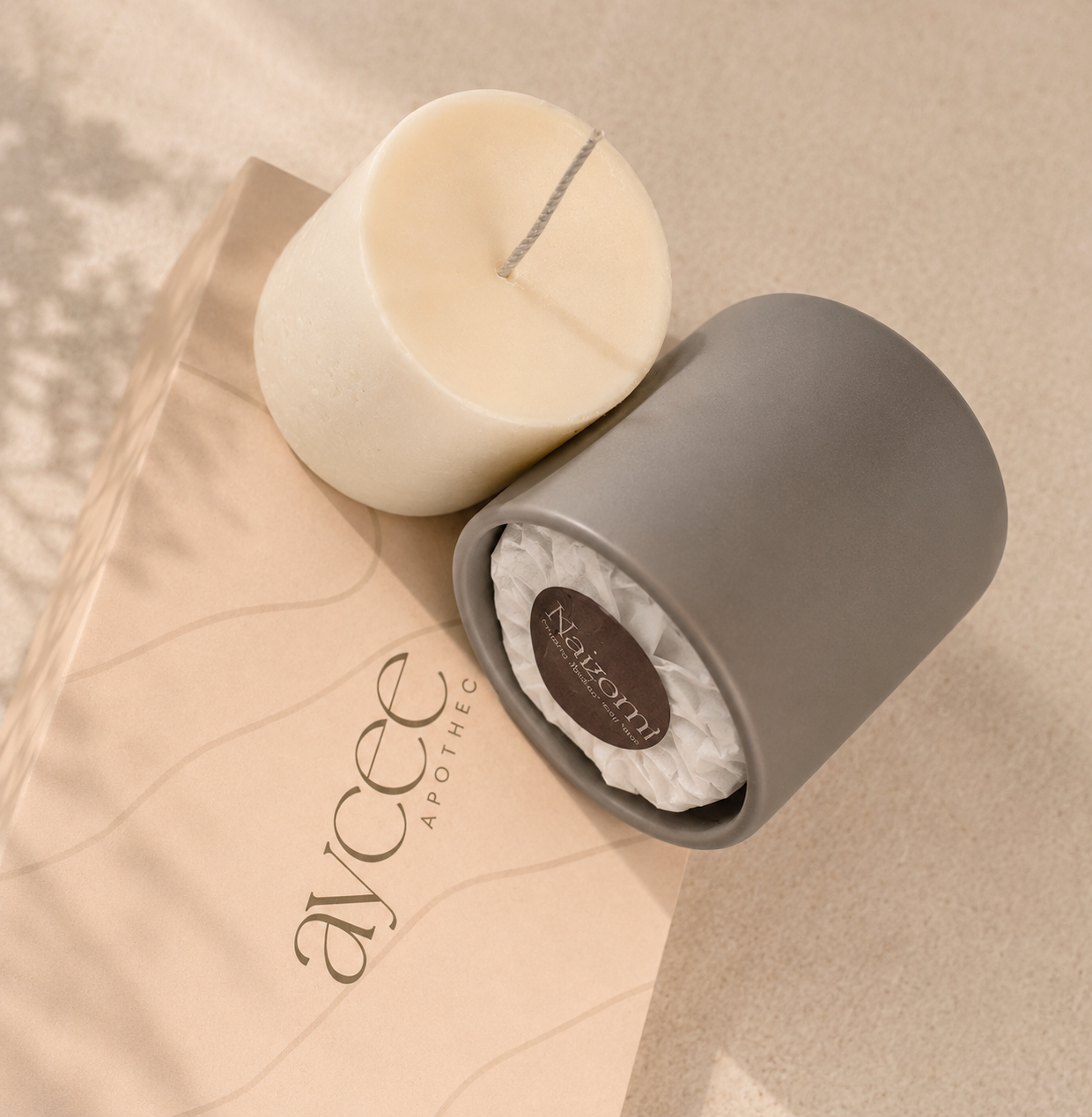 Grey candle jar with refill candle wax beside it