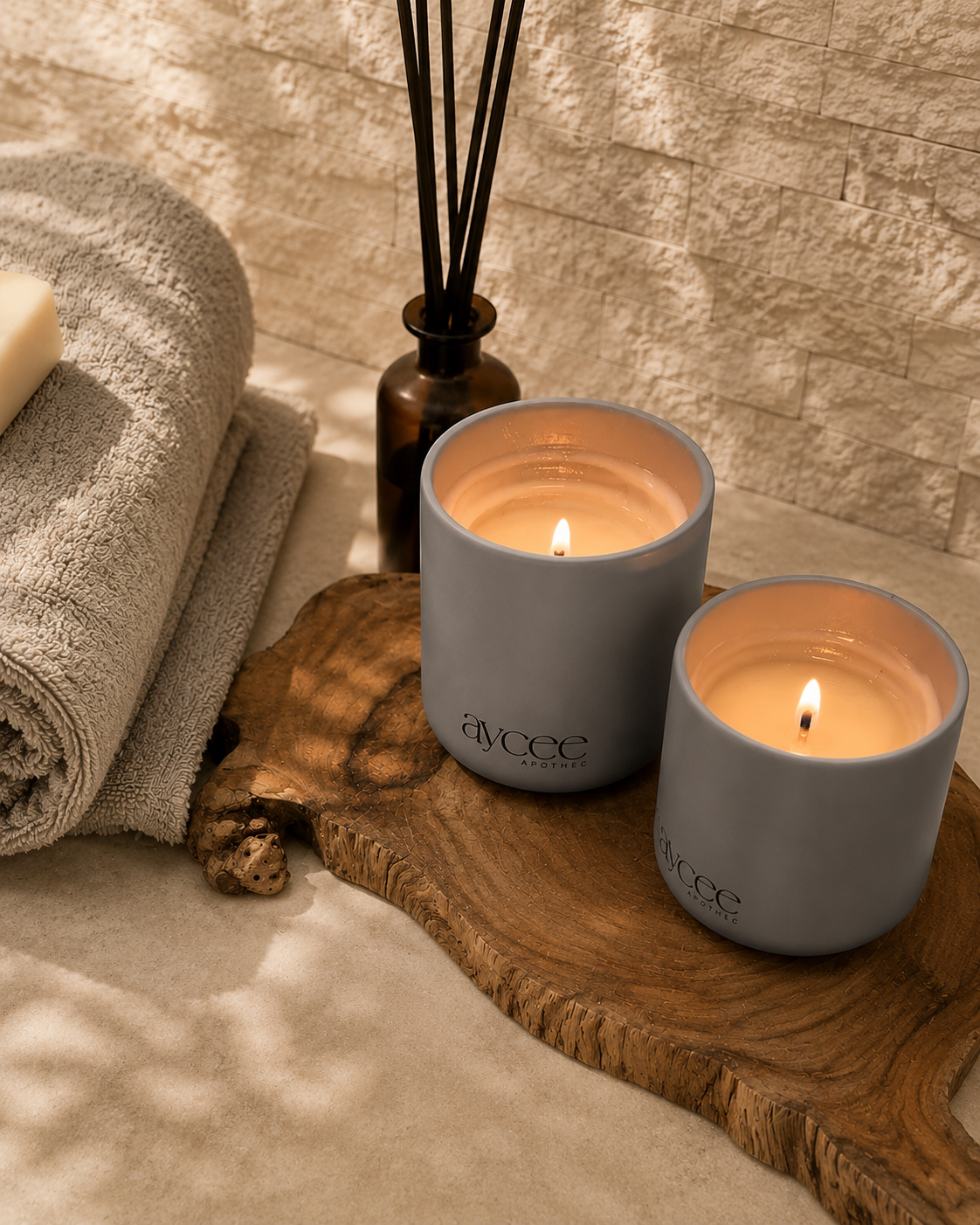 Two Nagomi candles in grey jars in a bathroom 