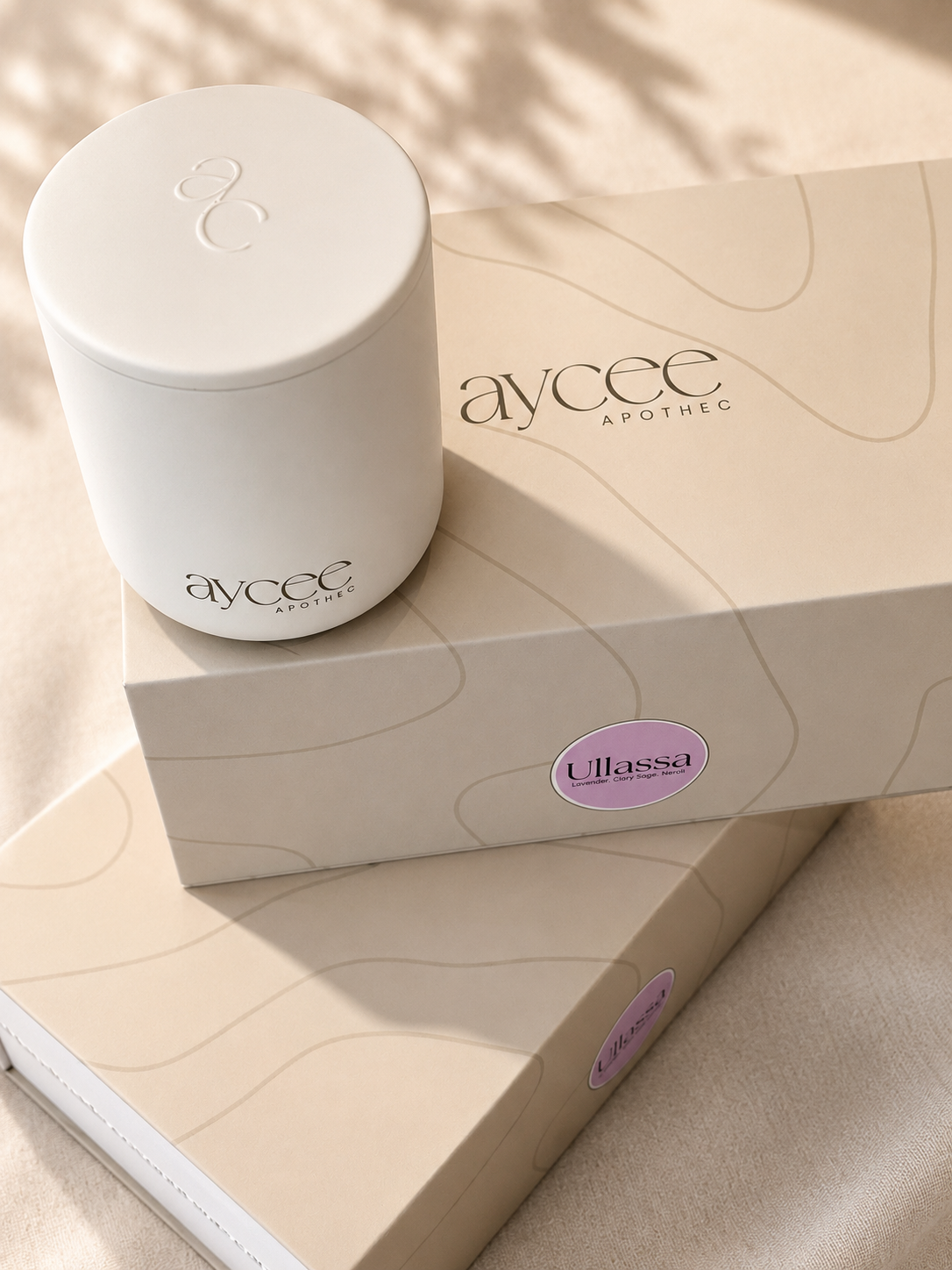 White ceramic candle container with 'Aycee Apothec' branding on a beige surface