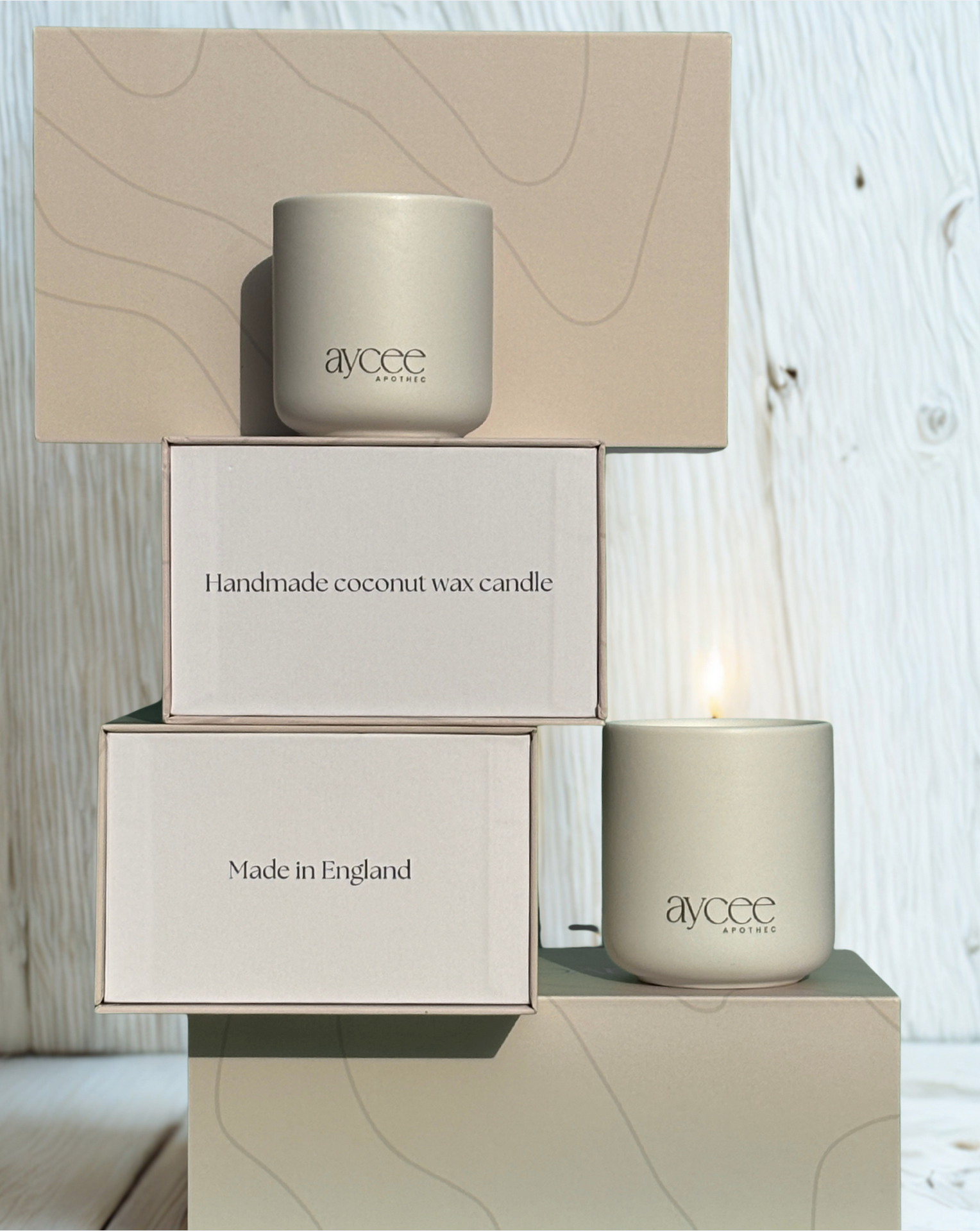 Aycee Apothec white ceramic candle jars with packaging on a wooden surface